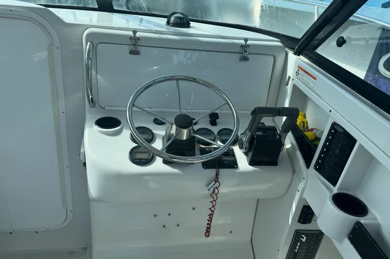 Slide: The Image of Helm of 2000 Glacier Bay 2680 Coastal Runner with steering wheel and controls. - 16
