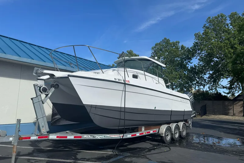 Slide: The Image of 2000 Glacier Bay 2680 Coastal Runner boat on trailer, parked outdoors under blue sky. - 3