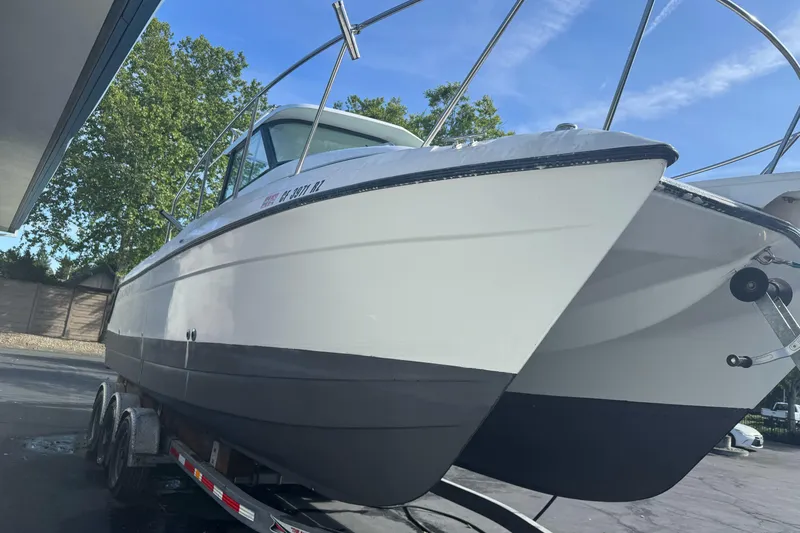 Slide: The Image of 2000 Glacier Bay 2680 Coastal Runner boat on trailer, parked outdoors under clear sky. - 7
