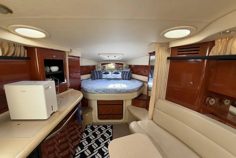 Slide: The Image of 2003 Sea Ray 340 Sundancer cabin interior with bed, seating, and kitchenette. - 13