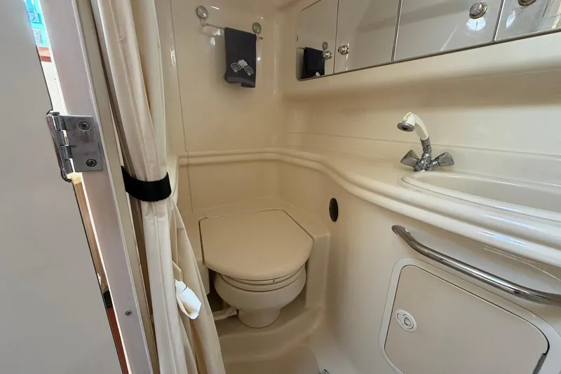 Slide: The Image of Compact bathroom in 2003 Sea Ray 340 Sundancer yacht, featuring toilet and sink. - 14