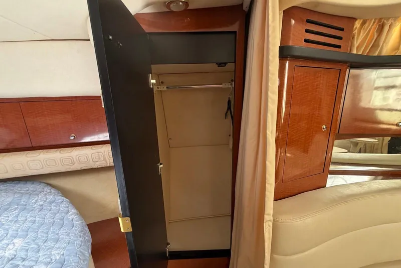 Slide: The Image of Interior of 2003 Sea Ray 340 Sundancer showing open closet and wooden cabinetry. - 17