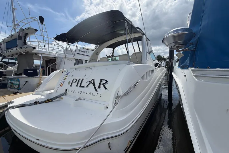 Slide: The Image of 2003 Sea Ray 340 Sundancer docked, featuring sleek design and "Pilar" name on the stern. - 2