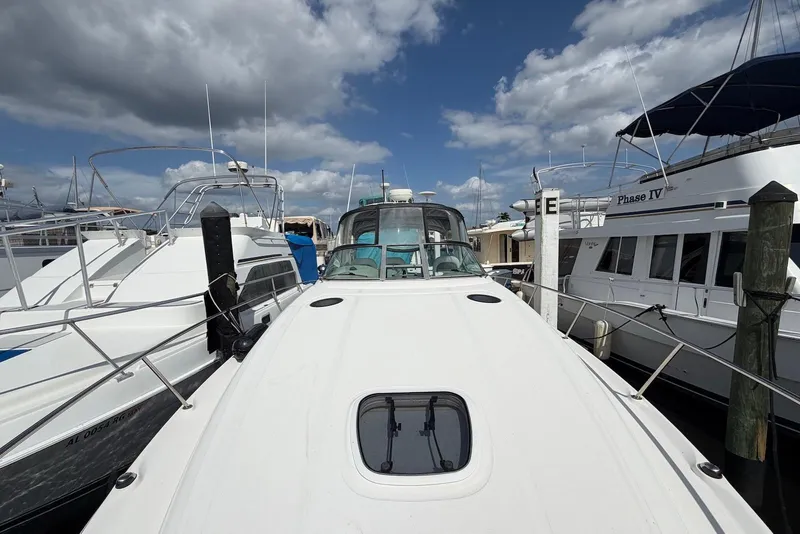 Slide: The Image of 2003 Sea Ray 340 Sundancer yacht docked at marina under cloudy sky. - 4