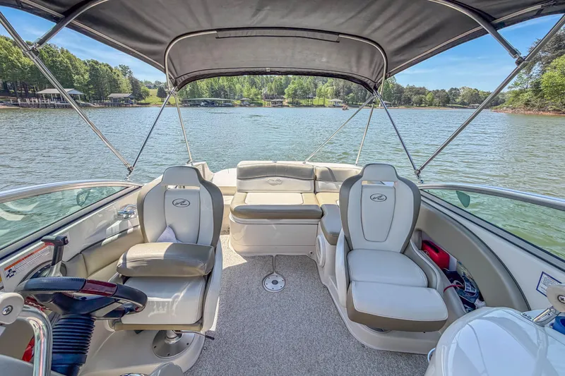 Slide: The Image of 2007 Sea Ray 220 Sundeck interior with seating, canopy, and lake view. - 13