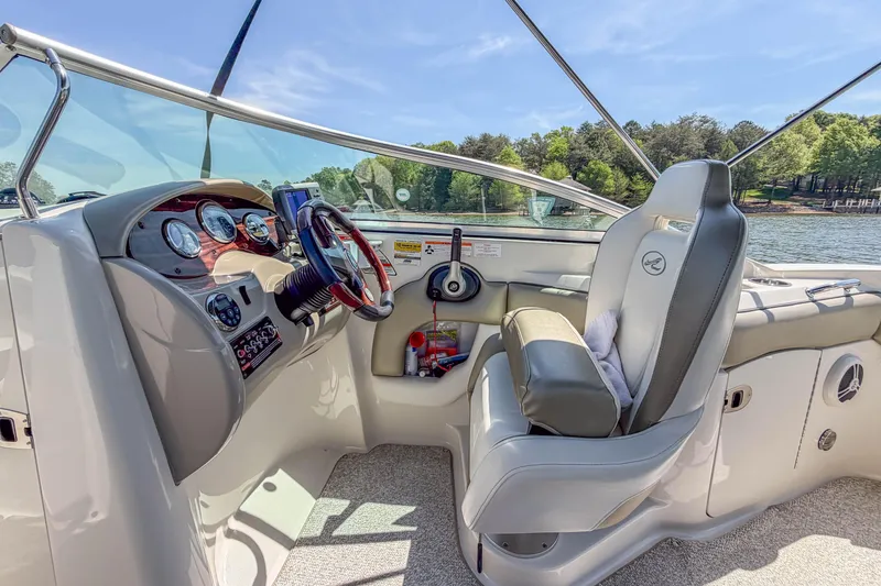 Slide: The Image of 2007 Sea Ray 220 Sundeck cockpit with steering wheel, gauges, and comfortable seating. - 14