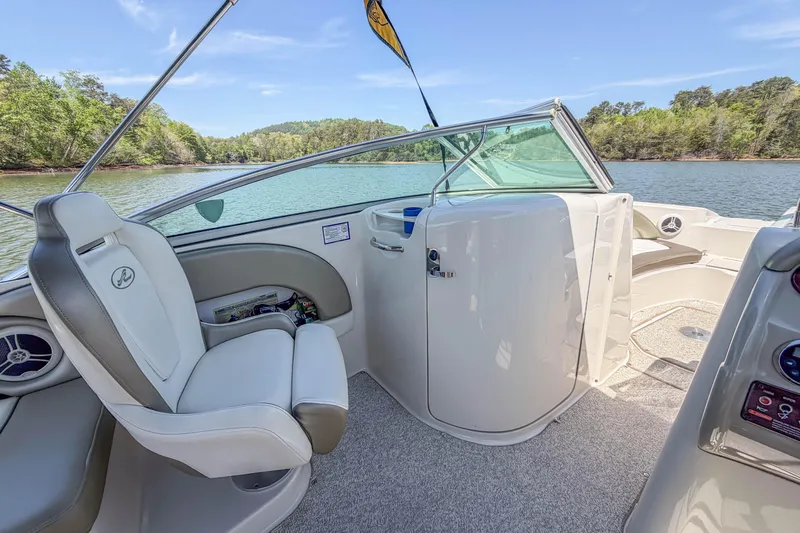 Slide: The Image of 2007 Sea Ray 220 Sundeck interior with helm seat, lake view, and clear skies. - 15