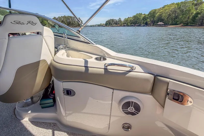Slide: The Image of 2007 Sea Ray 220 Sundeck interior with lake view, featuring seating and storage. - 17