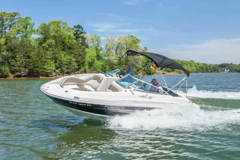 Slide: The Image of 2007 Sea Ray 220 Sundeck cruising on a scenic lake with lush green trees. - 4