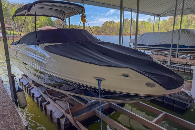 Slide: The Image of 2007 Sea Ray 220 Sundeck boat docked under a canopy on a lake. - 8