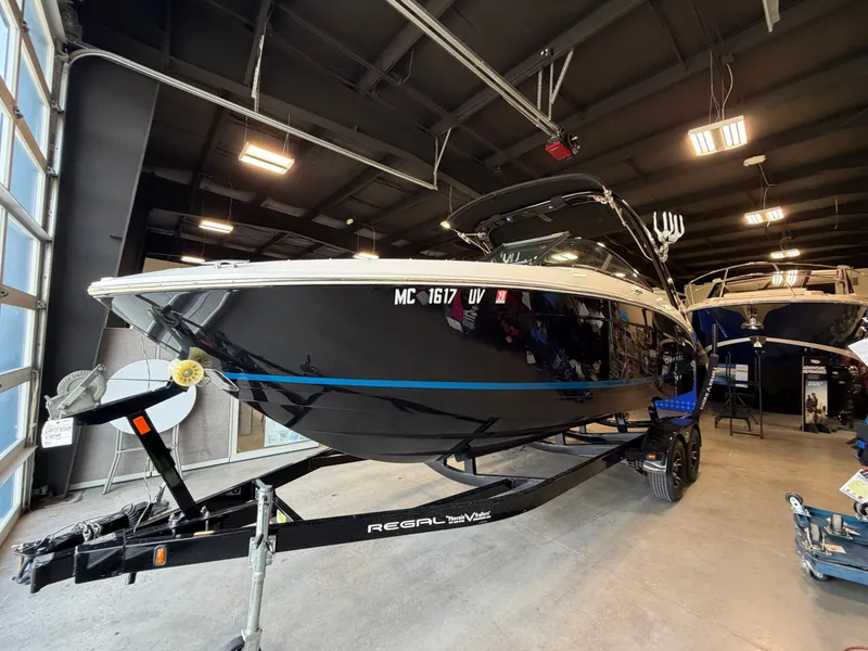 Slide: The Image of 2022 Regal LS4 Surf boat displayed in a showroom. - 2