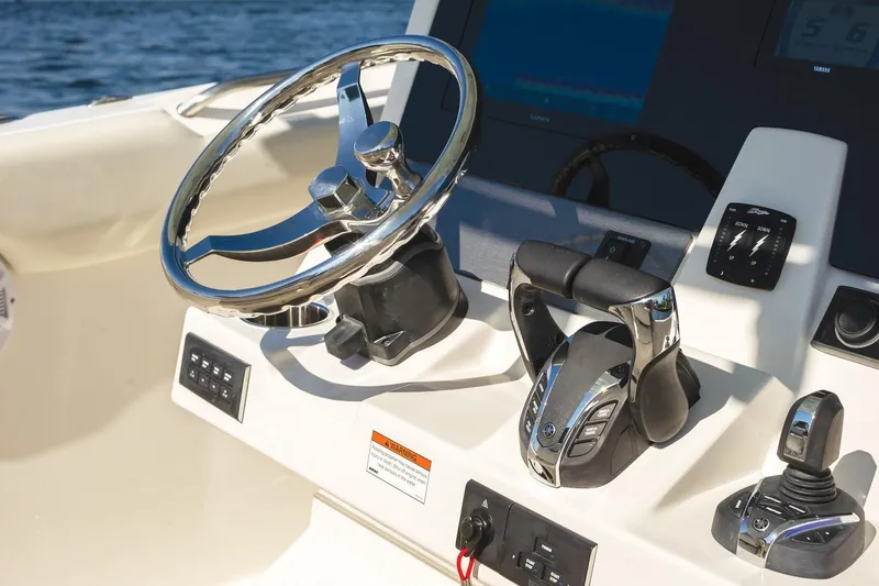 Slide: The Image of Steering console of 2027 Sailfish 312 CC boat with modern controls and chrome wheel. - 9