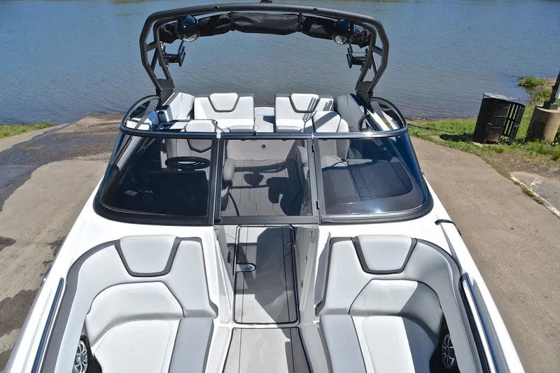 Slide: The Image of 2024 Yamaha Boats 252XE with sleek interior design, docked by a serene lake. - 20