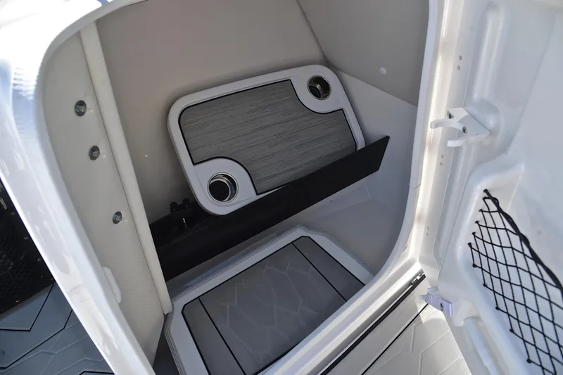 Slide: The Image of 2024 Yamaha Boats 252XE interior storage compartment with modern design and cup holders. - 27