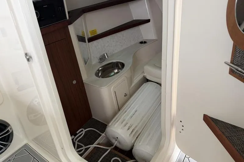 Slide: The Image of Interior of 2025 Grady-White Freedom 325 boat, featuring a compact sink and storage area. - 22