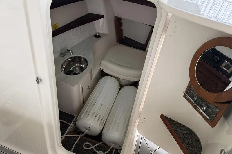 Slide: The Image of 2025 Grady-White Freedom 325 boat interior with sink, toilet, and storage space. - 23