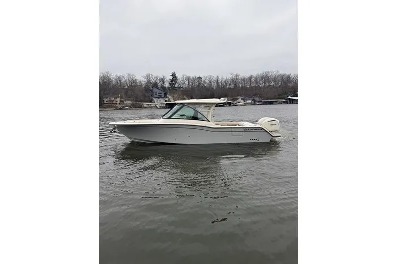 Slide: The Image of 2025 Grady-White Freedom 325 boat on a calm lake with wooded shoreline. - 8