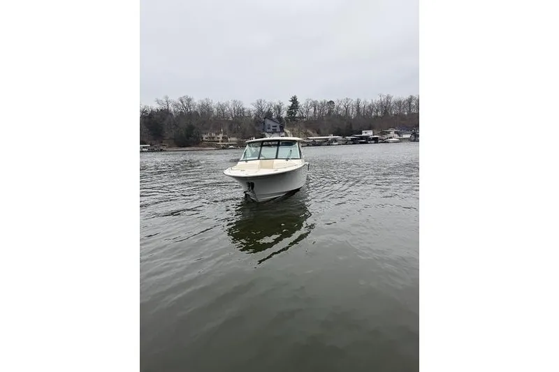 Slide: The Image of 2025 Grady-White Freedom 325 boat on a calm lake with wooded shoreline. - 9