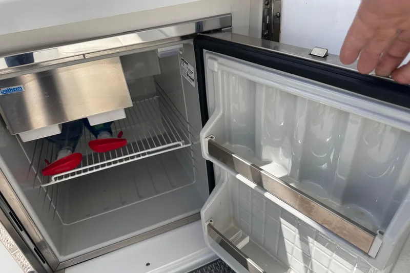 Slide: The Image of Open mini fridge on 2006 Formula 280 Bowrider boat, showing interior shelves and door storage. - 10