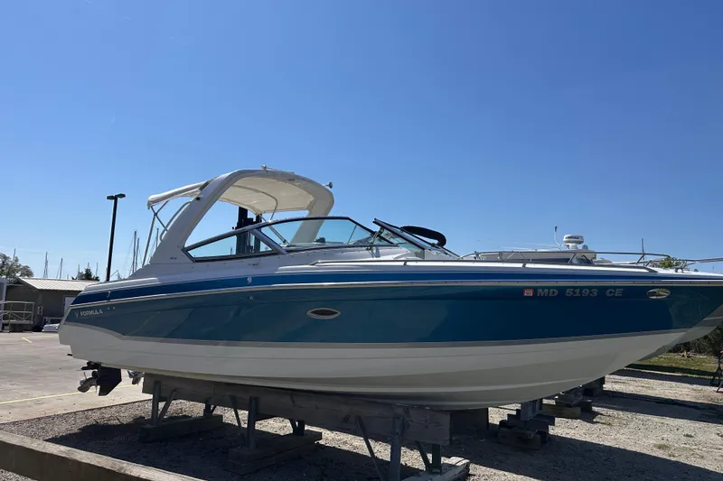 Slide: The Image of 2006 Formula 280 Bowrider boat on display, blue and white exterior, sunny day. - 2