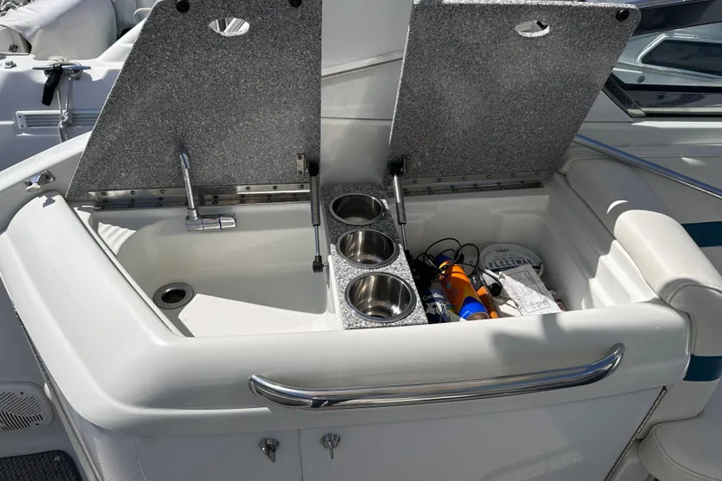Slide: The Image of 2006 Formula 280 Bowrider boat sink and storage area with open lids. - 8