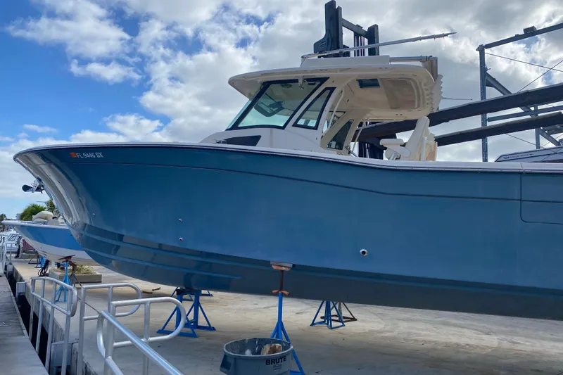 The Image of 2021 Grady-White Canyon 376 boat on stands, blue hull, marina setting. - 0