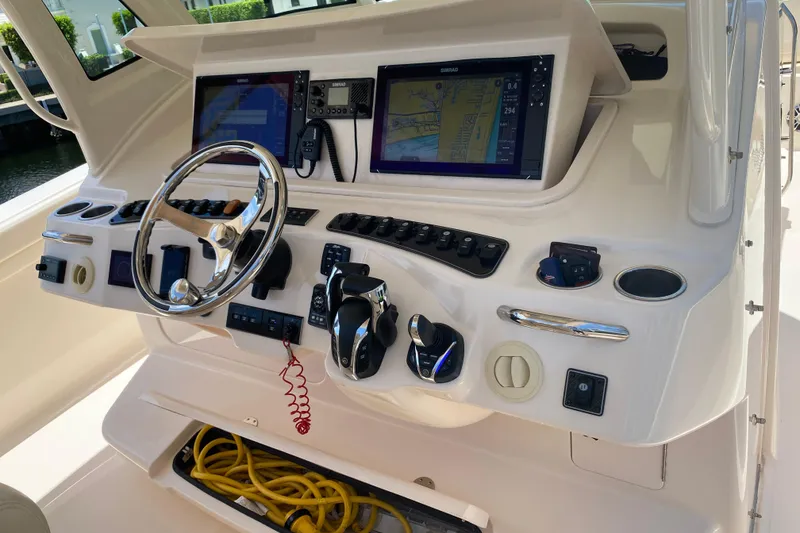 Slide: The Image of Control panel of a 2021 Grady-White Canyon 376 boat with navigation screens and steering wheel. - 13