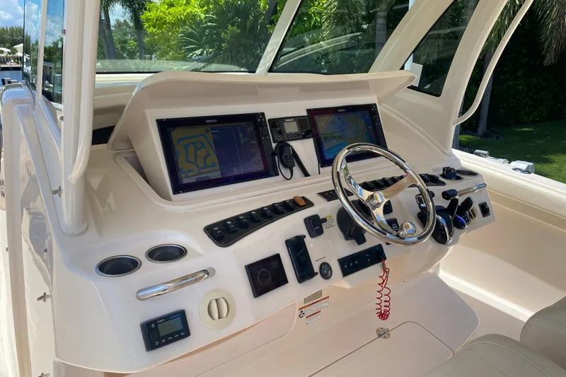 Slide: The Image of 2021 Grady-White Canyon 376 boat dashboard with navigation screens and steering wheel. - 14