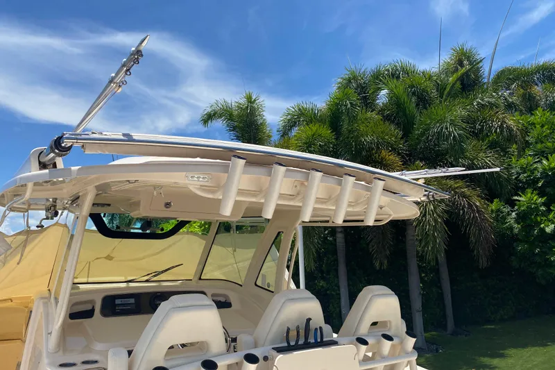 Slide: The Image of 2021 Grady-White Canyon 376 boat with rod holders, set against a tropical backdrop. - 19