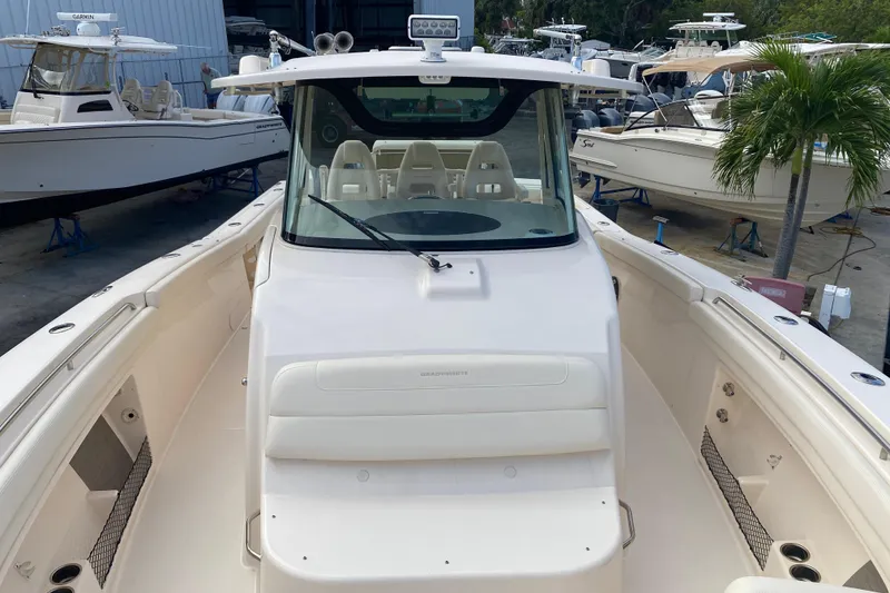 Slide: The Image of 2021 Grady-White Canyon 376 boat docked, showcasing spacious deck and seating area. - 5