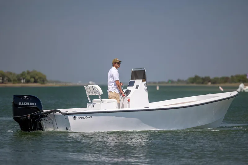 Slide: The Image of Man piloting a 2026 StroudCraft 2000 boat on a calm lake. - 3