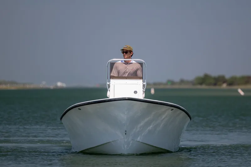 Slide: The Image of Man piloting a 2026 StroudCraft 2000 boat on a calm waterway. - 6