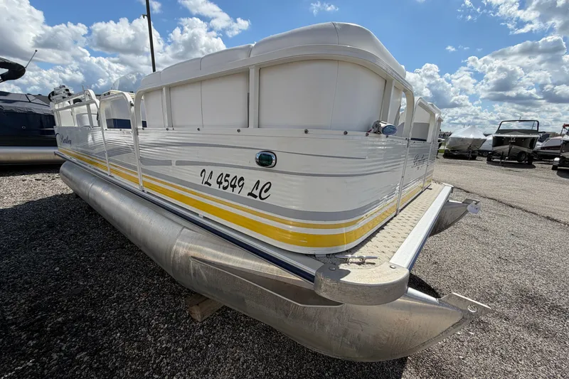 Slide: The Image of 2004 Bentley Pontoons 200 CRUISE pontoon boat on gravel lot under blue sky. - 17