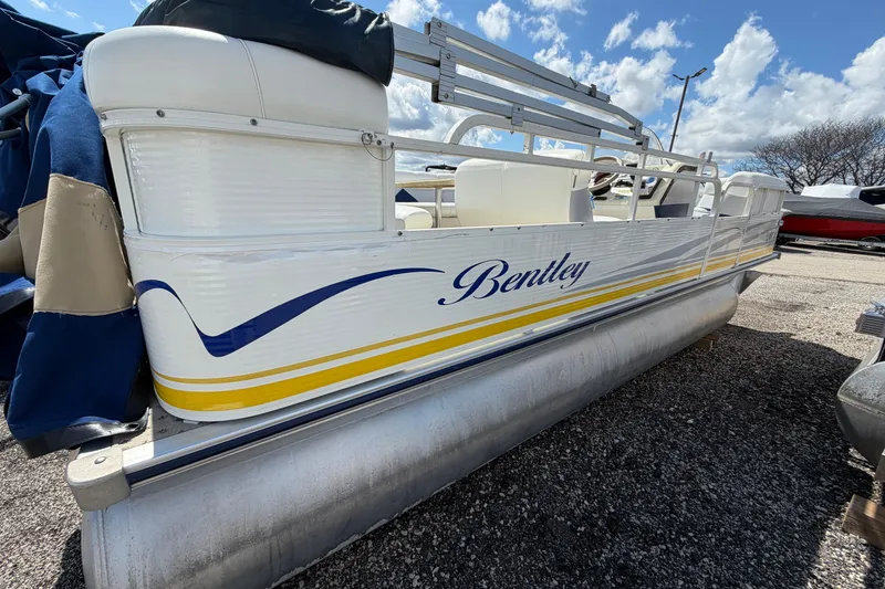 Slide: The Image of 2004 Bentley Pontoons 200 CRUISE boat on gravel, under a blue sky. - 3