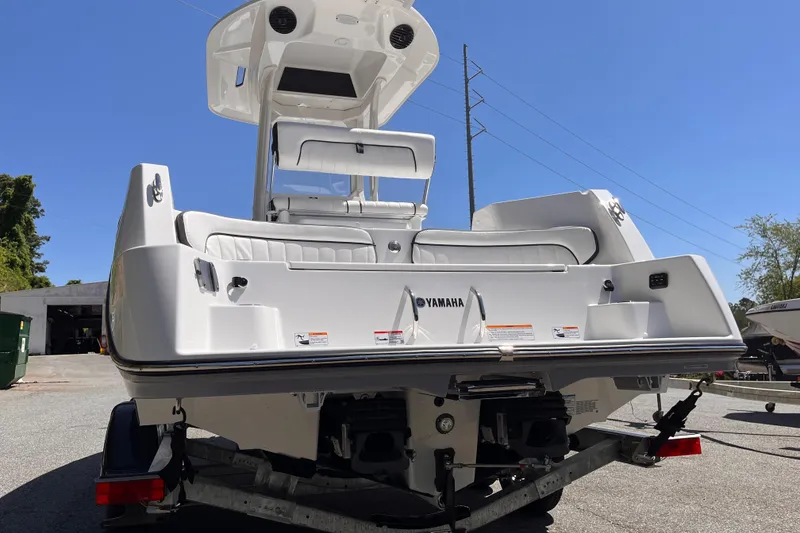 Slide: The Image of 2026 Yamaha Boats 222 FSH Sport E on trailer, rear view under clear sky. - 2