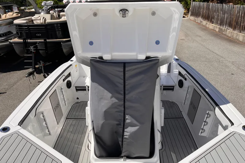 Slide: The Image of 2026 Yamaha Boats 222 FSH Sport E interior with open storage compartment and sleek design. - 7