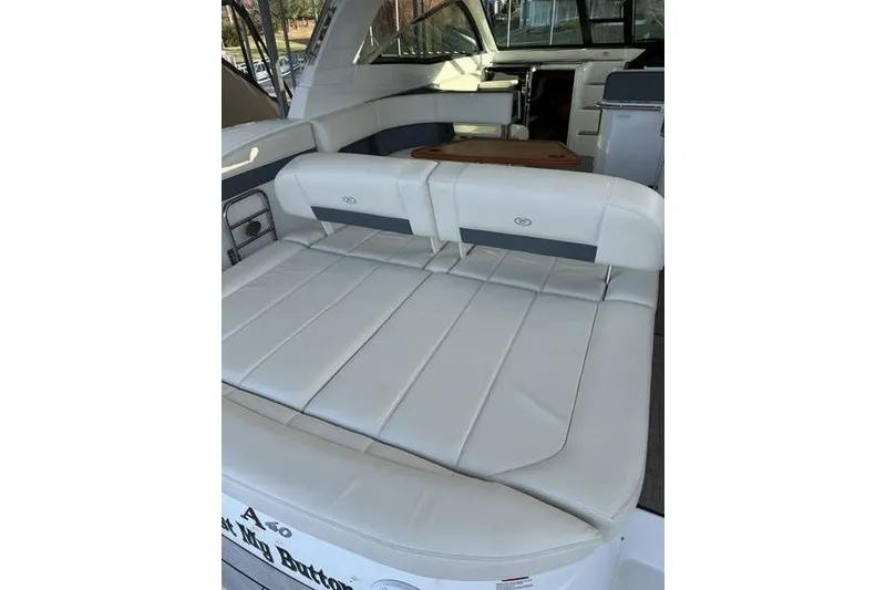 Slide: The Image of 2016 Cobalt A40 boat interior with white leather seating and wooden table. - 8
