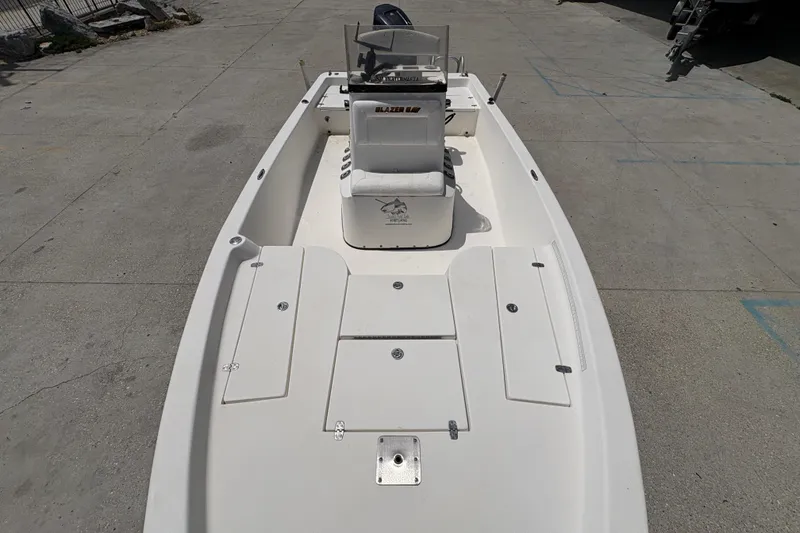Slide: The Image of 2005 Blazer Bay 2220 Professional boat, white interior, center console, docked on concrete surface. - 19