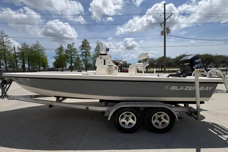 Slide: The Image of 2005 Blazer Bay Bay 2220 Professional boat on trailer under cloudy sky. - 7