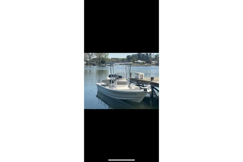 The Image of 2003 Sea Pro SV2100CC Bay Boat docked on a calm lake. - 1
