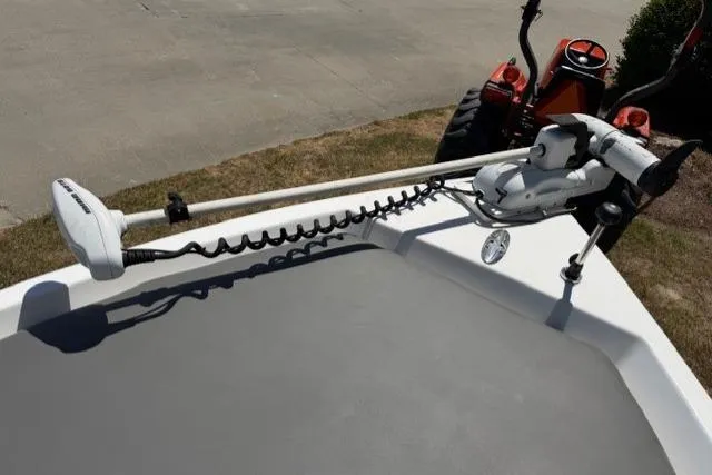 Slide: The Image of 2003 Sea Pro SV2100CC Bay Boat with trolling motor on deck, parked near a tractor. - 12