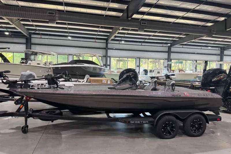 The Image of 2026 Skeeter ZXE20 boat in showroom, sleek design, dual motors, on trailer. - 0