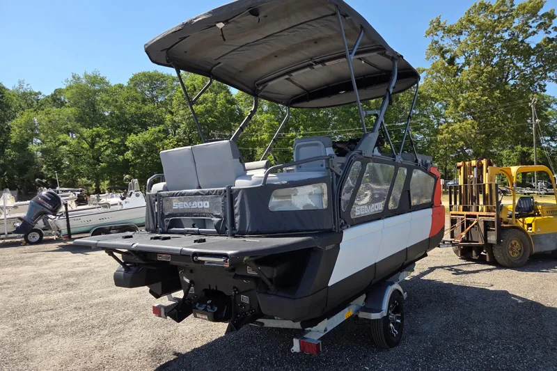 Slide: The Image of 2024 Sea-Doo Switch Cruise 18 pontoon boat with canopy, parked outdoors. - 4