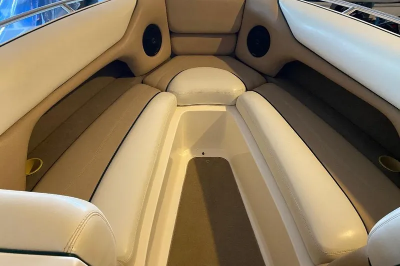 Slide: The Image of Interior seating of a 2001 Malibu Sunscape 25 LSV boat, featuring beige upholstery. - 10