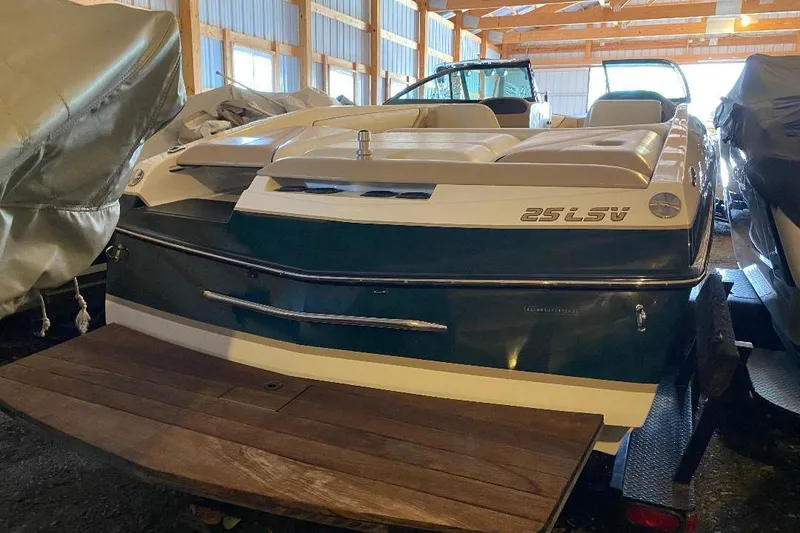 Slide: The Image of 2001 Malibu Sunscape 25 LSV boat in storage, rear view with wooden deck. - 12
