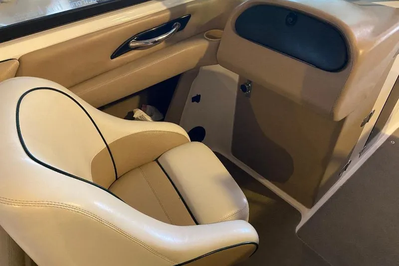 Slide: The Image of Interior of a 2001 Malibu Sunscape 25 LSV boat, featuring beige seating and dashboard. - 16