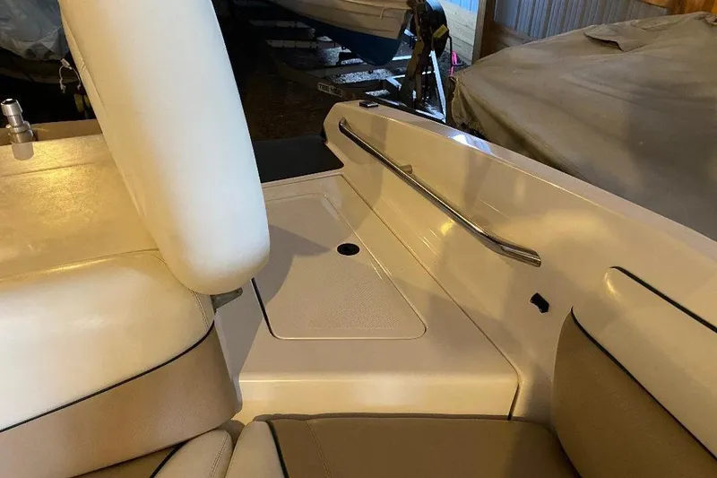 Slide: The Image of Interior of a 2001 Malibu Sunscape 25 LSV boat, featuring beige seating and storage area. - 18