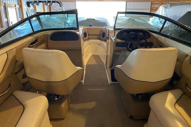 Slide: The Image of Interior of a 2001 Malibu Sunscape 25 LSV boat with beige seating and dashboard. - 21