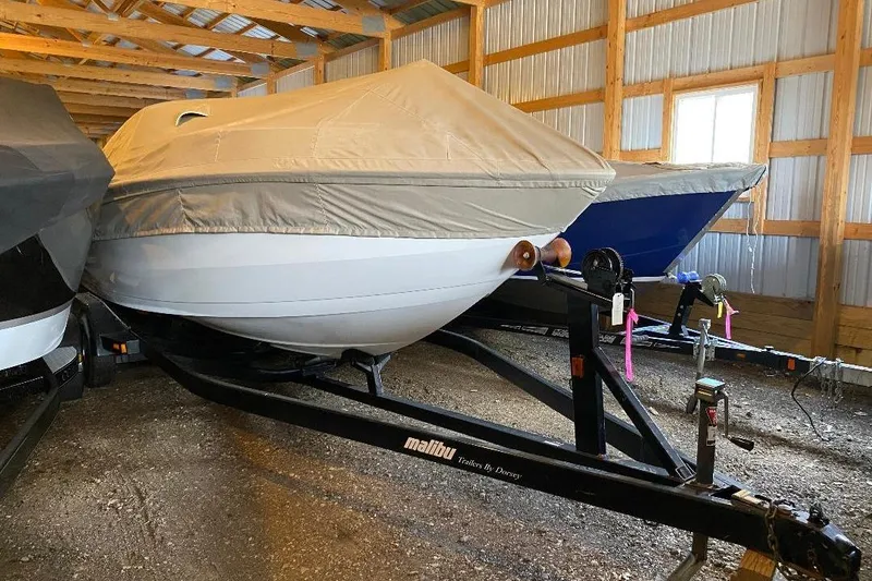 Slide: The Image of 2001 Malibu Sunscape 25 LSV boat covered and stored in a wooden garage. - 3