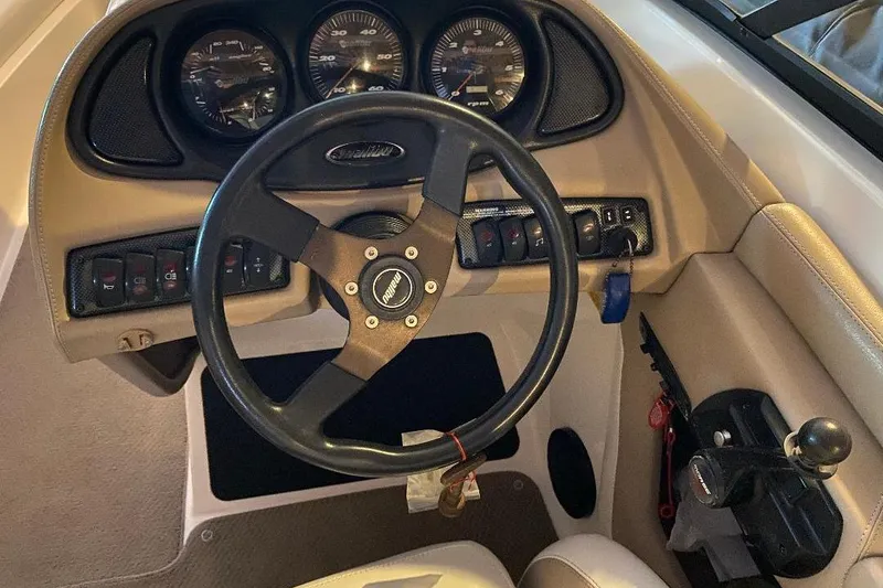 Slide: The Image of 2001 Malibu Sunscape 25 LSV boat dashboard with steering wheel and control panel. - 8